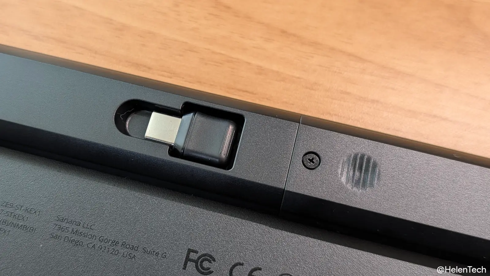 Satechi Slim EX1 Wireless Keyboard の背面にある USB-C レシーバーのスロットと、バッテリーにアクセスするためのネジ部分が写った写真