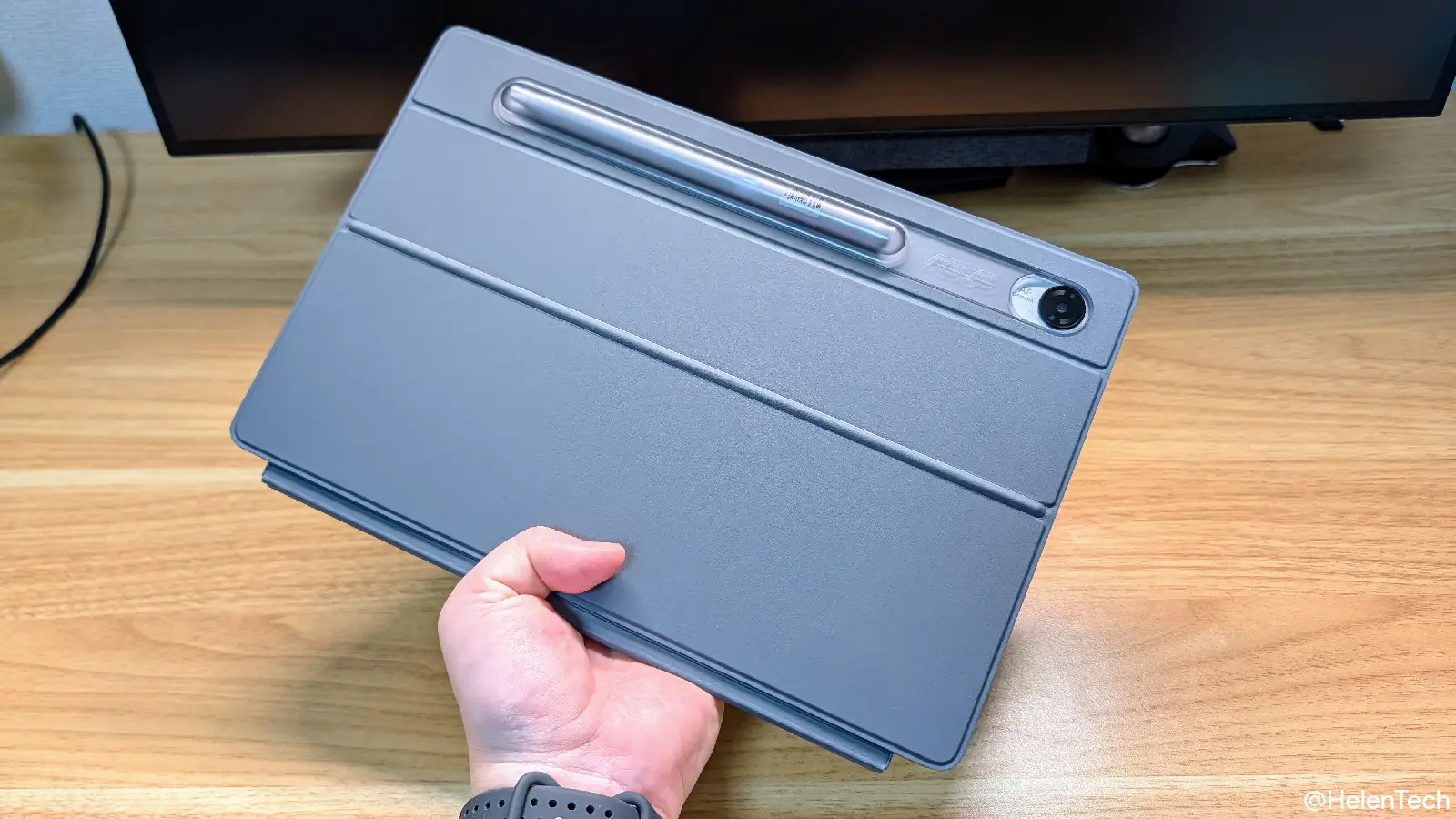 ASUS Chromebook CM32 Detachable を片手で持ち上げて、背面を見せている様子の写真